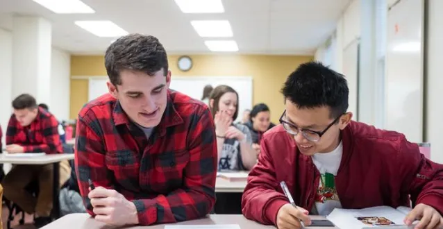 Two male students working together in class