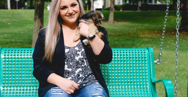 Hannah Garofalo with her puppy sitting on a bench