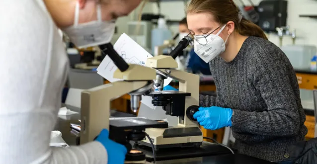 Female student looking through a microscope