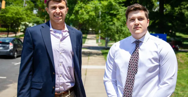 Eric DeLong and Logan Isner standing outside