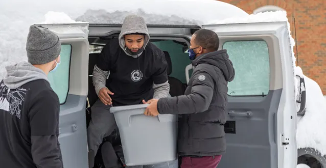 Students loading boxes in a van