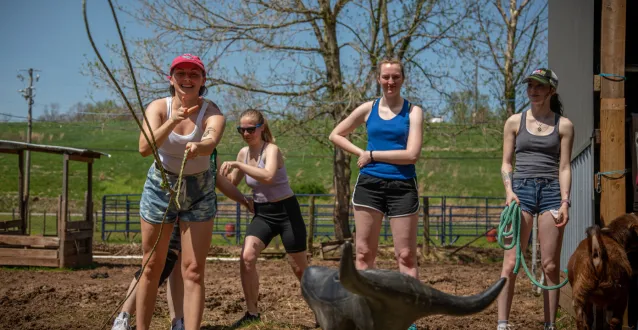 Students practice roping a fake cow