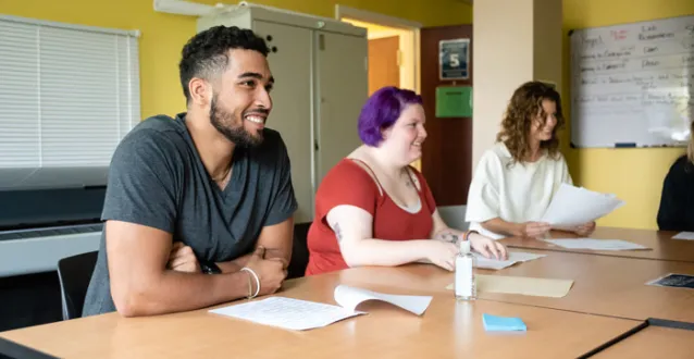 Students seated at a table, smiling