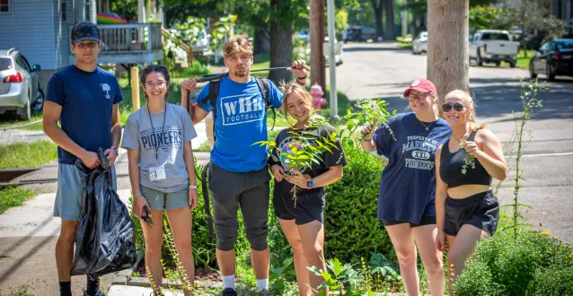 Six Marietta College students working outside on a landscaping service project