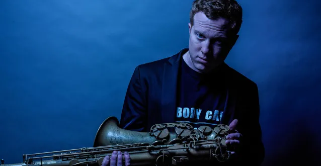 Adam Larson posing with a saxophone