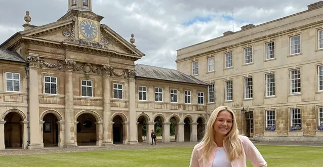 Student posing in front of building