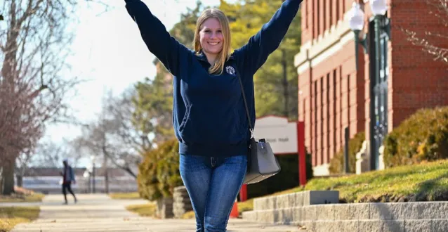 Female student with hands in the air