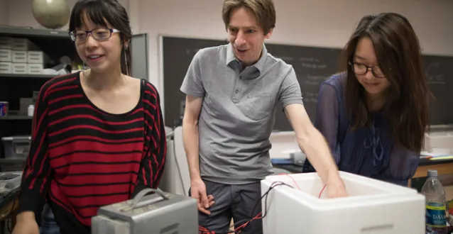 Physics students working with a professor