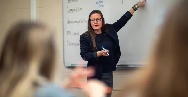 Professor teaching from a white board