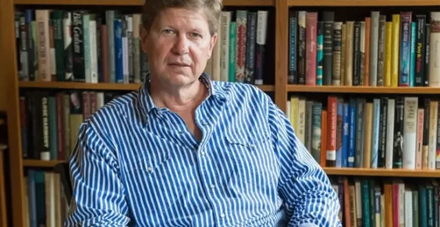 Randall Balmer seated in front of a bookcase