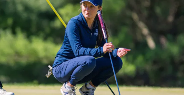 Helena Immel crouched down on a golf course