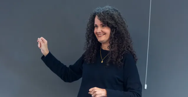 Marietta College Professor stands next to chalkboard