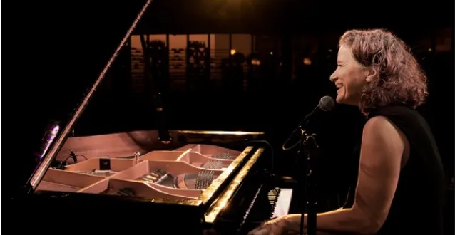 Susan Werner plays piano in a concert hall