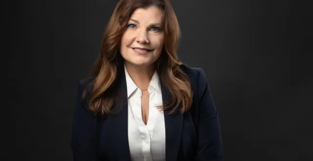 Amy Elliot smiles with her arms crossed in front of her