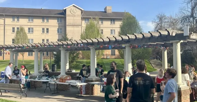 Students gather on Harrison Lawn with refreshments, cultural decor