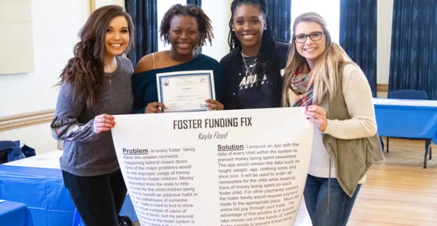 Students holding up a poster from Junior PioBiz