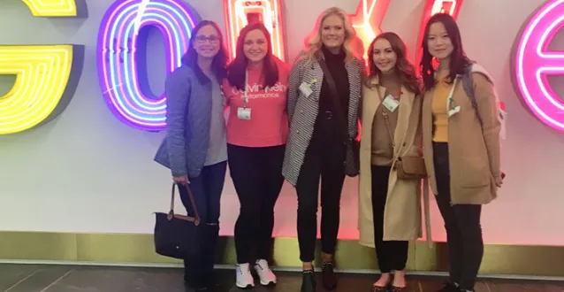 Group photo of students and faculty member in front of Google sign