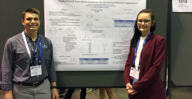 Dr. Jim Jeitler and Shannon Patberg standing in front of a research poster