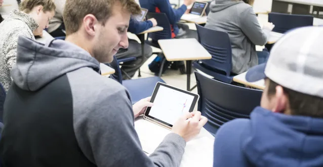 Students looking at an iPad in class