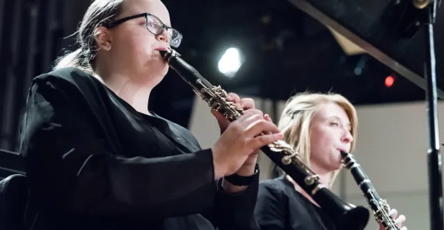 Two females playing clarinets