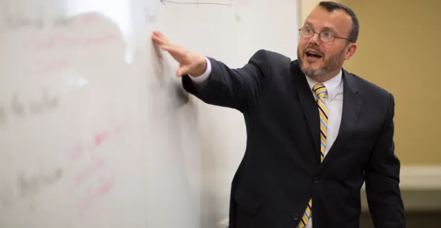 Gama Perruci pointing at a white board