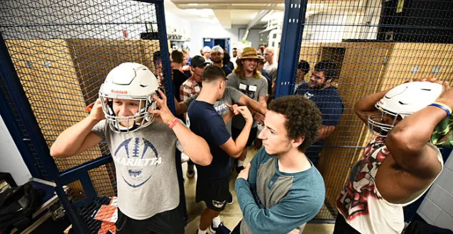 Marietta football players trying on helmets