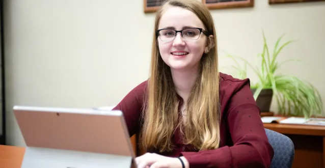 Student Ashley Klopfenstein sitting behind a computer