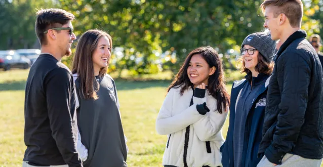 Harrison Scholars - Gabe Brunck, Emi Reindle, Hanna Jamelo, Anna Frost and Artemii Stepanets - chat during halftime of a football game.