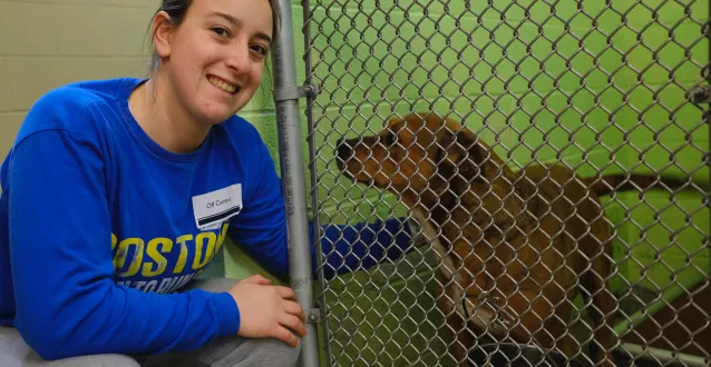 Female student petting a dog at the humane society