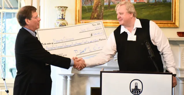 President Ruud shakes the hand of David Goldenberg during a check presentation