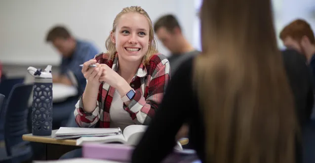 Female student speaking with another student in class