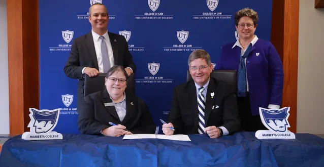 University administrators gathered for a form signing