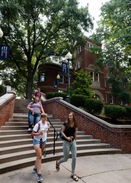 Students walk down the stairs toward the Rickey Science enterance