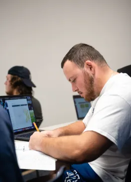 A student taking notes during a class at Marietta College