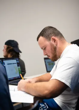 An economics major takes notes during an econ class.