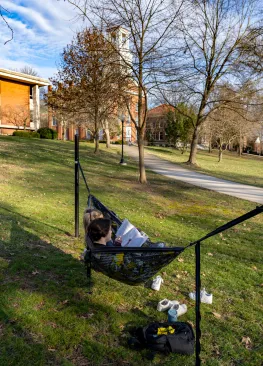 Two students studying in a hammock on the Marietta College campus.