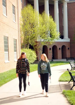 Two Marietta College students walk outside of their residence hall