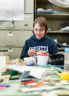 A geology major works with rocks in a lab