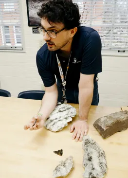 Geology Professor Andrew Beck shows a rock to geology majors during class