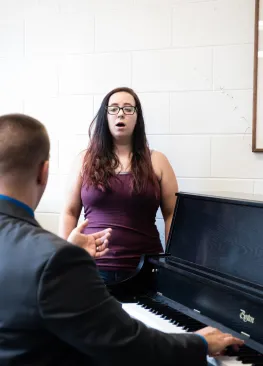 A Marietta College music major sings while a professor plays piano and instructs.