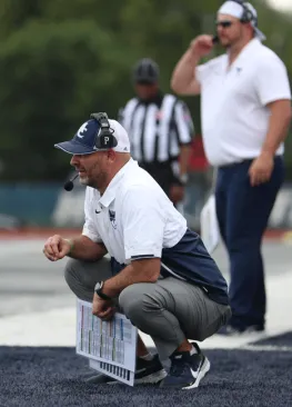 Andy Waddle kneeling on the sideline