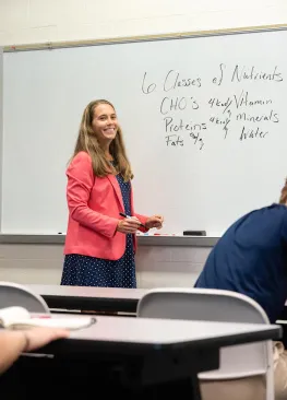 A Marietta College professor stands at a white board