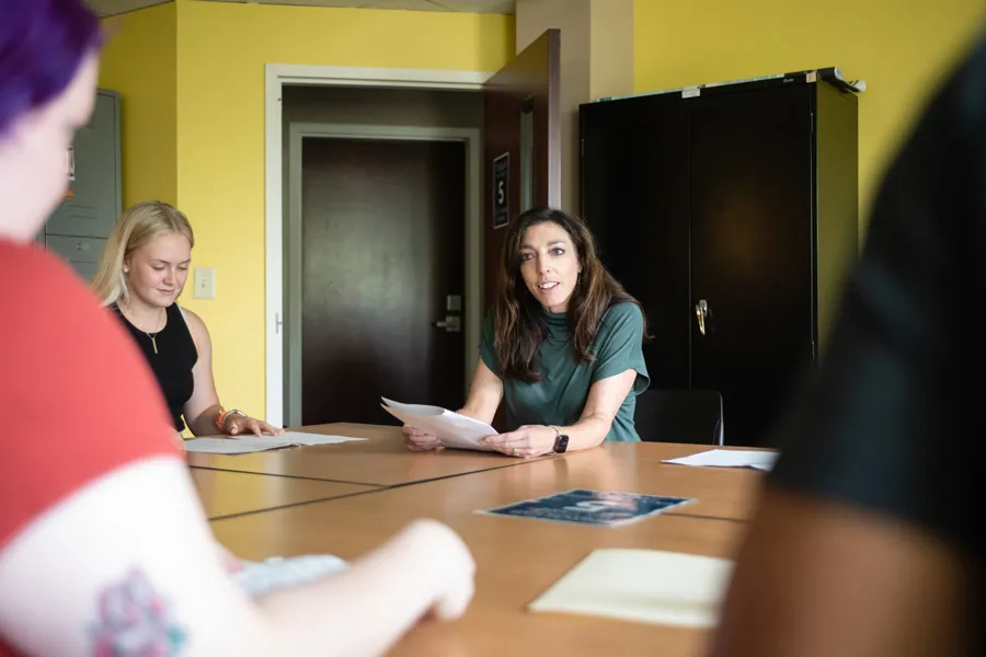 Dr. Ali Doerflinger sitting at a table with students